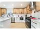 Bright kitchen features white cabinets, stainless steel appliances, and wooden upper cabinets at 4237 E Twain Ave, Las Vegas, NV 89121