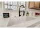 Close up of bright white kitchen sink with a modern faucet with white tile backsplash at 4237 E Twain Ave, Las Vegas, NV 89121