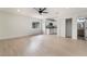 Open-concept living room with wood-look flooring, ceiling fan, and a view of the kitchen and bathroom at 4237 E Twain Ave, Las Vegas, NV 89121