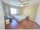 This cozy bedroom features hardwood floors, a ceiling fan, and a bright window at 451 Rumford Pl, Henderson, NV 89074