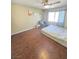 This cozy bedroom features hardwood floors, a ceiling fan, and a bright window at 451 Rumford Pl, Henderson, NV 89074