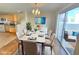 Elegant dining room with modern decor, opening to a bright outdoor view and kitchen space at 451 Rumford Pl, Henderson, NV 89074