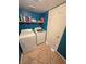 Laundry room area with washer, dryer, storage shelf, and tiled floors at 451 Rumford Pl, Henderson, NV 89074