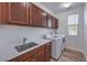 This laundry room features a sink, cabinets, quartz counters, and a new washer and dryer at 508 Cadence View Way, Henderson, NV 89011