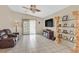 Relaxing living room with tile flooring, a ceiling fan, and sliding glass doors to the backyard at 5109 Midnight Oil Dr, Las Vegas, NV 89122