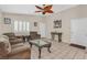 Bright living room featuring tile flooring, comfortable seating, and an eye-catching ceiling fan at 5109 Midnight Oil Dr, Las Vegas, NV 89122