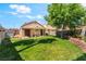 Spacious backyard with lush lawn, mature tree, patio area, and charming desert landscaping at 5725 Cedar Ave, Las Vegas, NV 89110