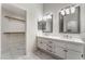Bright bathroom features dual sinks, framed mirrors, white cabinetry, and a large walk-in closet at 5725 Cedar Ave, Las Vegas, NV 89110