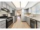Modern kitchen featuring stainless steel appliances, light blue cabinets and a view of the living room at 5725 Cedar Ave, Las Vegas, NV 89110