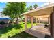 Relaxing covered patio and backyard featuring mature trees and beautiful landscaping at 5725 Cedar Ave, Las Vegas, NV 89110