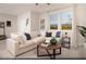 Inviting living room with a large sectional sofa, decorative rug, and abundant natural light from the expansive windows at 624 Bellus Pl # Lot 170, Henderson, NV 89015