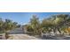 Spacious property with a three-car garage, desert landscaping, and a white fence at 6325 Guy Ave Ave, Las Vegas, NV 89131