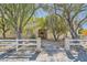 Inviting front entrance with desert landscaping, mature trees, and a white picket fence at 6325 Guy Ave Ave, Las Vegas, NV 89131