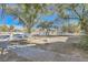 Expansive front yard with mature trees, gravel landscaping, and a white fence at 6325 Guy Ave Ave, Las Vegas, NV 89131