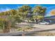 Landscaped yard with a modern car, mature trees, and natural desert accents at 6325 Guy Ave Ave, Las Vegas, NV 89131