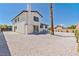 Exterior of home showing a gravel backyard and a tall palm tree at 652 Del Prado Dr, Boulder City, NV 89005
