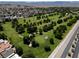 An aerial view shows a beautiful golf course with green grass, trees, and a neighborhood in the background at 652 Del Prado Dr, Boulder City, NV 89005
