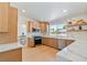 Bright kitchen with natural wood cabinetry, stainless steel appliances, and marble countertops at 652 Del Prado Dr, Boulder City, NV 89005