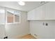 Functional laundry room with white cabinets, storage space, and a window for natural light at 652 Del Prado Dr, Boulder City, NV 89005