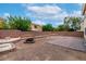 Landscaped backyard featuring multiple areas with rock and stone borders around the central fire pit at 6558 Musette Ave, Las Vegas, NV 89139