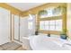 Bright bathroom features a soaking tub, a glass shower, and natural light at 6558 Musette Ave, Las Vegas, NV 89139