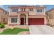 Two-story home with a red roof, red garage doors, and manicured lawn at 6558 Musette Ave, Las Vegas, NV 89139