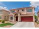 Two-story home with a red roof, red garage doors, and manicured lawn at 6558 Musette Ave, Las Vegas, NV 89139