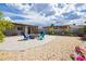 Cozy backyard with brick patio, fire pit, and Adirondack chairs surrounded by desert landscaping at 67 Oklahoma Dr, Henderson, NV 89015