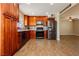 Updated kitchen with cherry cabinets, stainless steel appliances, and tile flooring, perfect for modern living at 67 Oklahoma Dr, Henderson, NV 89015