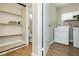 Well-organized laundry area with washer, dryer, shelving and wood look tile flooring at 67 Oklahoma Dr, Henderson, NV 89015