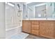 This bathroom boasts dual sinks with wood cabinets, a showerhead, and tub at 6739 Twisted Wood Dr, Las Vegas, NV 89148
