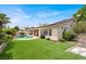 Backyard with a well-maintained lawn, pool, patio, and lush, mature tropical landscaping at 7511 Bridlehorne Ave, Las Vegas, NV 89131
