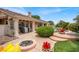 View of the backyard with a fire pit, lush landscaping, and a glimpse of a pool and patio at 7511 Bridlehorne Ave, Las Vegas, NV 89131