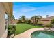 Well-manicured backyard featuring a lush lawn, mature trees, and a cozy pool area at 7511 Bridlehorne Ave, Las Vegas, NV 89131