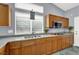Close up of the long kitchen counter with sink, stainless steel appliances, and wood cabinetry at 7511 Bridlehorne Ave, Las Vegas, NV 89131