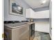 Laundry room with a modern washer and dryer, white cabinets, counters and artistic wall decor at 7511 Bridlehorne Ave, Las Vegas, NV 89131