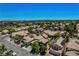 Overview of homes in a suburban neighborhood featuring tiled roofs and desert landscaping on a clear, sunny day at 7625 Raven Hills Dr, Las Vegas, NV 89149