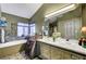 Bathroom with double sinks, large mirror, soaking tub, and travertine tile at 7625 Raven Hills Dr, Las Vegas, NV 89149