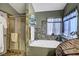 Relaxing bathroom featuring a jetted tub, glass-enclosed shower, and elegant decor at 7625 Raven Hills Dr, Las Vegas, NV 89149