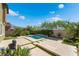 Private backyard featuring a pool with a waterfall feature, green grass and desert landscaping at 7732 Bandon Cliffs St, North Las Vegas, NV 89084