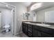 Modern bathroom featuring dual sinks, dark cabinets, granite countertops, and tile floor at 7732 Bandon Cliffs St, North Las Vegas, NV 89084