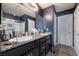 Modern bathroom with dual sinks, granite countertops, dark cabinets, and a glass-enclosed shower at 7732 Bandon Cliffs St, North Las Vegas, NV 89084