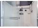 Modern shower featuring sleek glass doors, white tile, and built-in shelving for convenient storage at 7732 Bandon Cliffs St, North Las Vegas, NV 89084