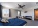 Bright bedroom featuring a ceiling fan, cozy carpet, and a partial view of an adjacent bathroom at 7732 Bandon Cliffs St, North Las Vegas, NV 89084