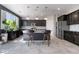 Modern kitchen features dark cabinetry, stainless steel appliances, tiled backsplash, and stylish island with barstool seating at 7732 Bandon Cliffs St, North Las Vegas, NV 89084
