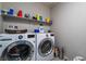 Functional laundry room with modern front load washer and dryer and extra storage space at 7732 Bandon Cliffs St, North Las Vegas, NV 89084