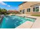 Backyard pool featuring a built in waterfall, desert landscaping, and beautiful blue water at 7732 Bandon Cliffs St, North Las Vegas, NV 89084