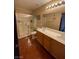 Bathroom featuring dual sinks, vanity with storage, walk-in shower, and wood floors at 7801 Olympus Ave, Las Vegas, NV 89131