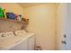Functional laundry room with a washer, dryer, and shelving for storing supplies at 7801 Olympus Ave, Las Vegas, NV 89131