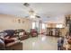 Spacious living room with tile floors, ceiling fan, and an open layout to the kitchen area at 7801 Olympus Ave, Las Vegas, NV 89131